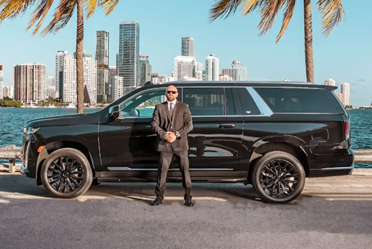 Driver Ready Beside a Cadillac Escalade for VIP Limo Service in West Palm Beach